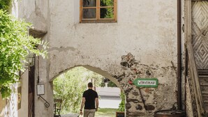 Une rue pavée menant à un bâtiment doté d’une porte en bois et d’une fenêtre.