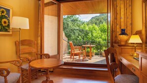Un interior de madera con balcón, muebles de madera y un cuadro de girasoles.