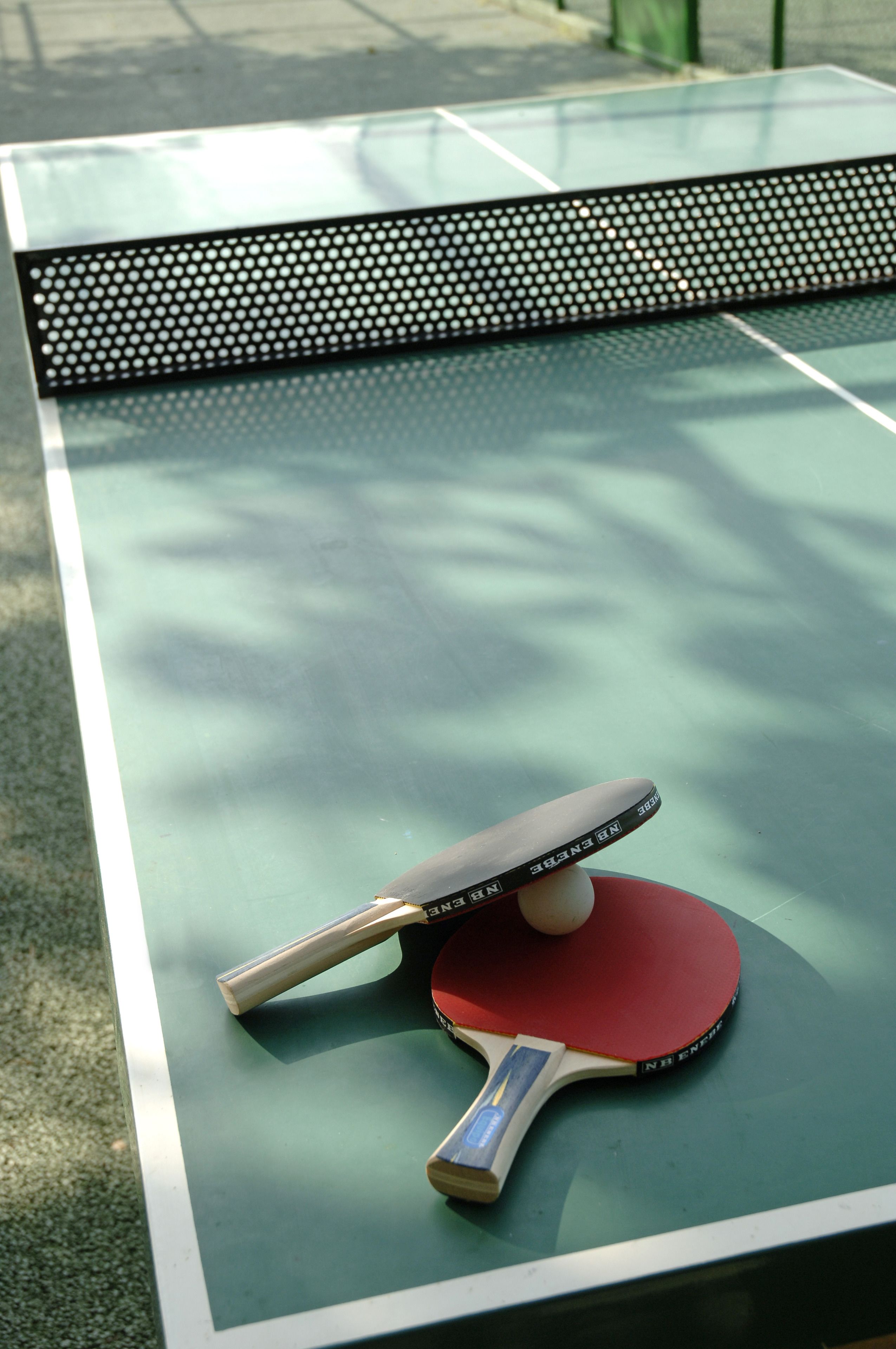 Een tafeltennistafel met batje en bal.