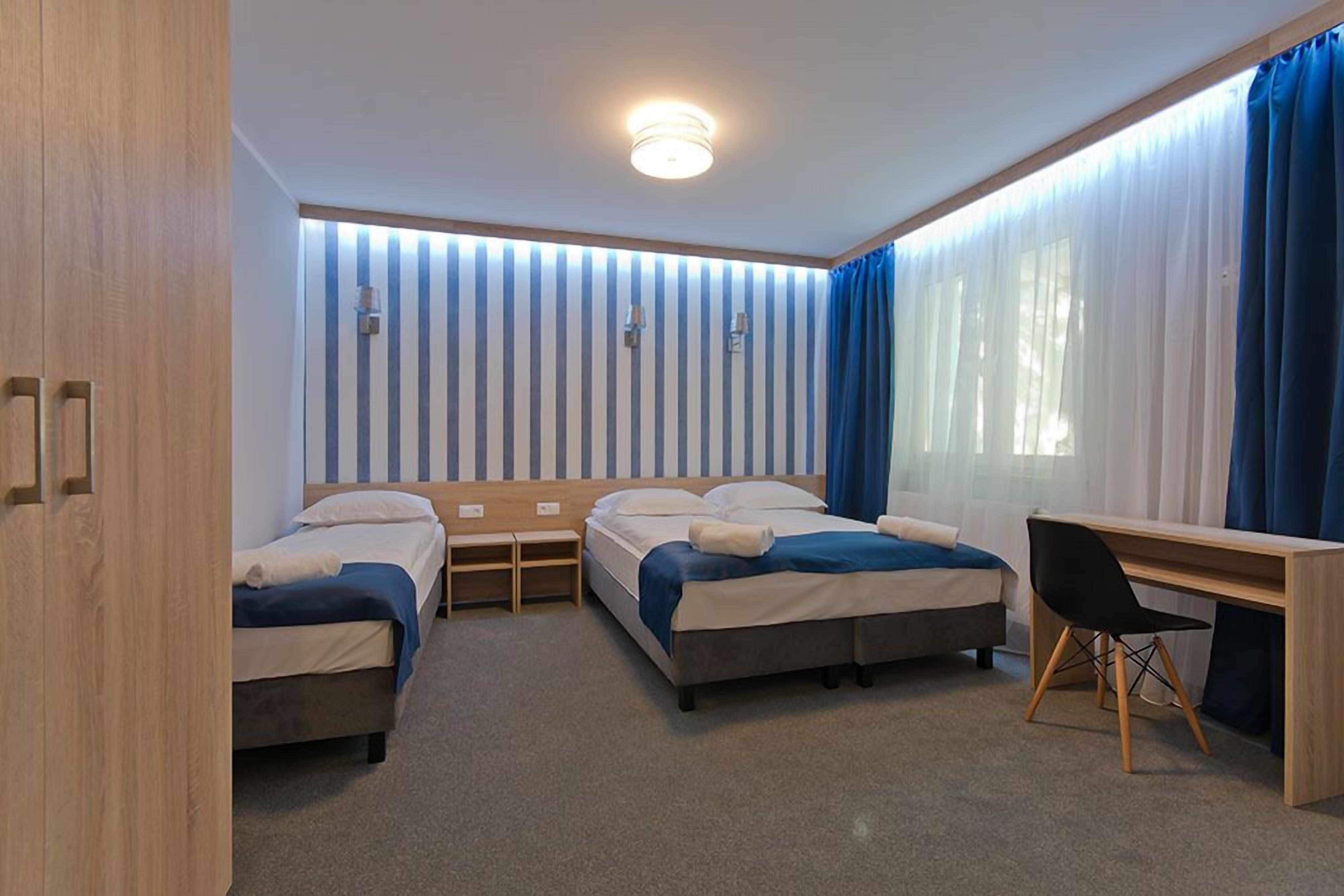 Une chambre avec deux lits, un bureau et une chaise.