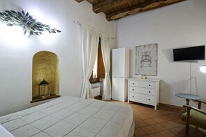 A bedroom with a bed, a wardrobe, a television, and a small table. - Corte Segreta Apartments (Salerno)