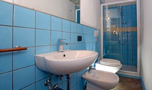 A bathroom with a white sink, a toilet, and a shower area. - Corte Segreta Apartments (Salerno)