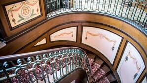 A curved staircase with ornate metal railings and patterned wall panels. - Château de la Gressière (La Bernerie-en-Retz)