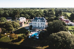 A large, historic mansion with a swimming pool, surrounded by lush greenery and other buildings. - Château de la Gressière (La Bernerie-en-Retz)