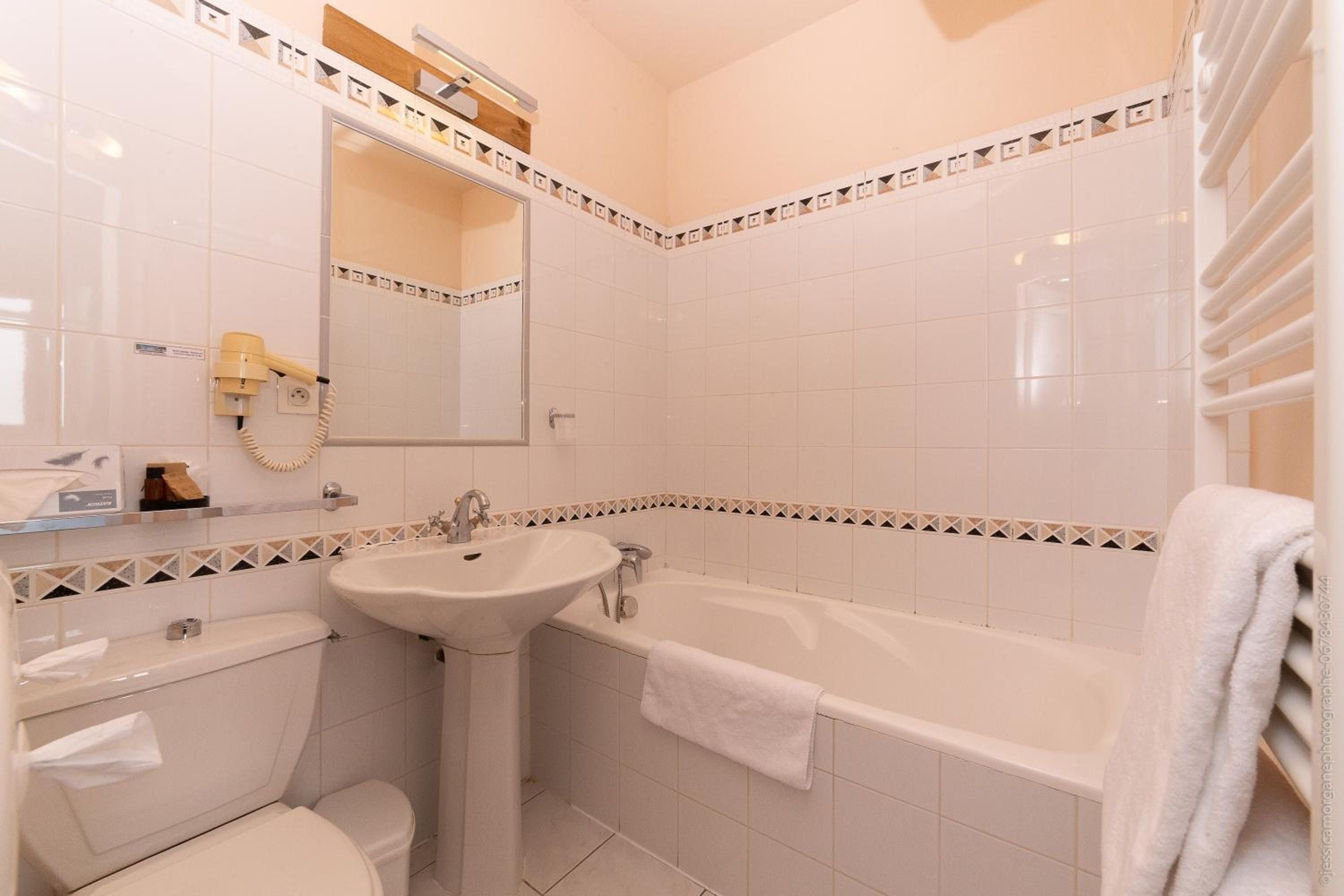 Une salle de bain avec des toilettes, un lavabo et une baignoire.