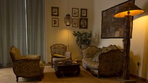 A living room with vintage furniture, a coffee table, a floor lamp, and a wall-mounted artwork. - Dimora dei Giganti (Naples)
