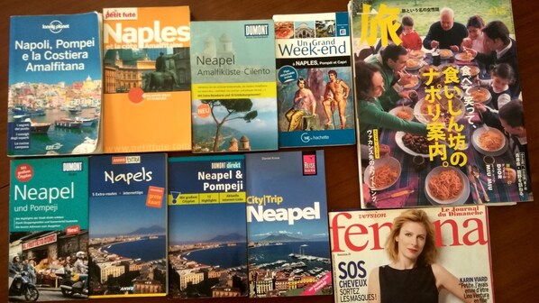 A collection of travel guides and magazines with various city names and destinations. - Dimora dei Giganti (Naples)