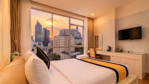 A hotel room with a large window, a bed, a desk, and a flat-screen TV. - Golden Star Hotel (Ho Chi Minh City)