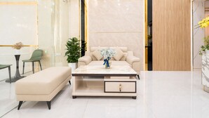 A modern hotel lobby with a sofa, a coffee table, a bench, and a plant. - Golden Star Hotel (Ho Chi Minh City)