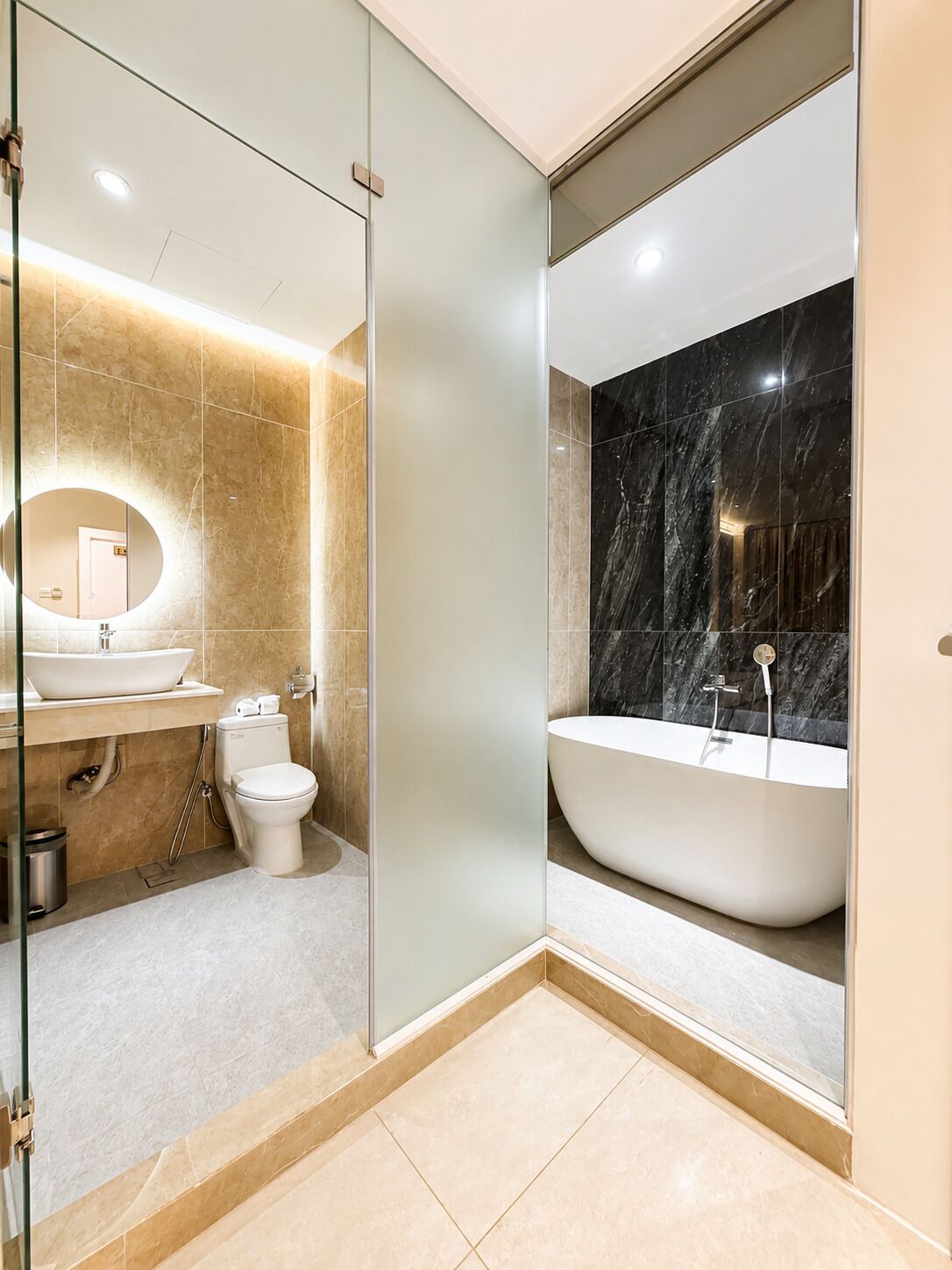 A modern bathroom with a glass-enclosed shower, a freestanding bathtub, and a toilet.