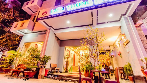 The exterior of Lien Thong Hotel with a well-lit entrance, potted plants, and outdoor seating area. - Lien Thong Hotel (Phu Quoc)