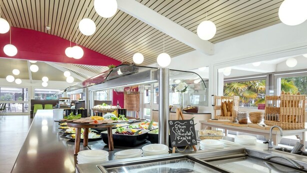 A buffet area with a variety of food options, a chalkboard menu, and a view of the outdoors.