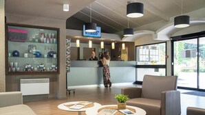 A reception area with a counter, a television, and seating with magazines.