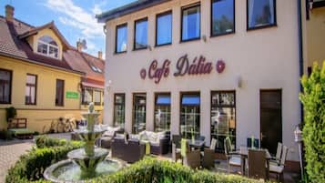 Un caffè chiamato Café Dália con posti a sedere all'aperto e una fontana.