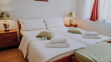 Habitación de hotel con cama doble, dos mesitas de noche y un aparador de madera.