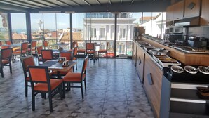 A spacious restaurant with high ceilings, large windows, and a view of the cityscape. - Apple Tree Hotel (Istanbul)