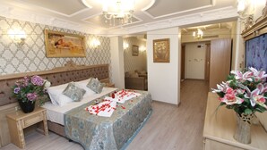 A bedroom with a large bed, a nightstand, a dresser, and a mirror. - Apple Tree Hotel (Istanbul)