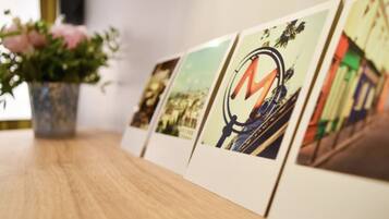Varias fotografías enmarcadas sobre una mesa de madera, con una planta en maceta al fondo.