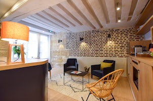 Un interior moderno con pared de piedra, muebles de madera y una lámpara.