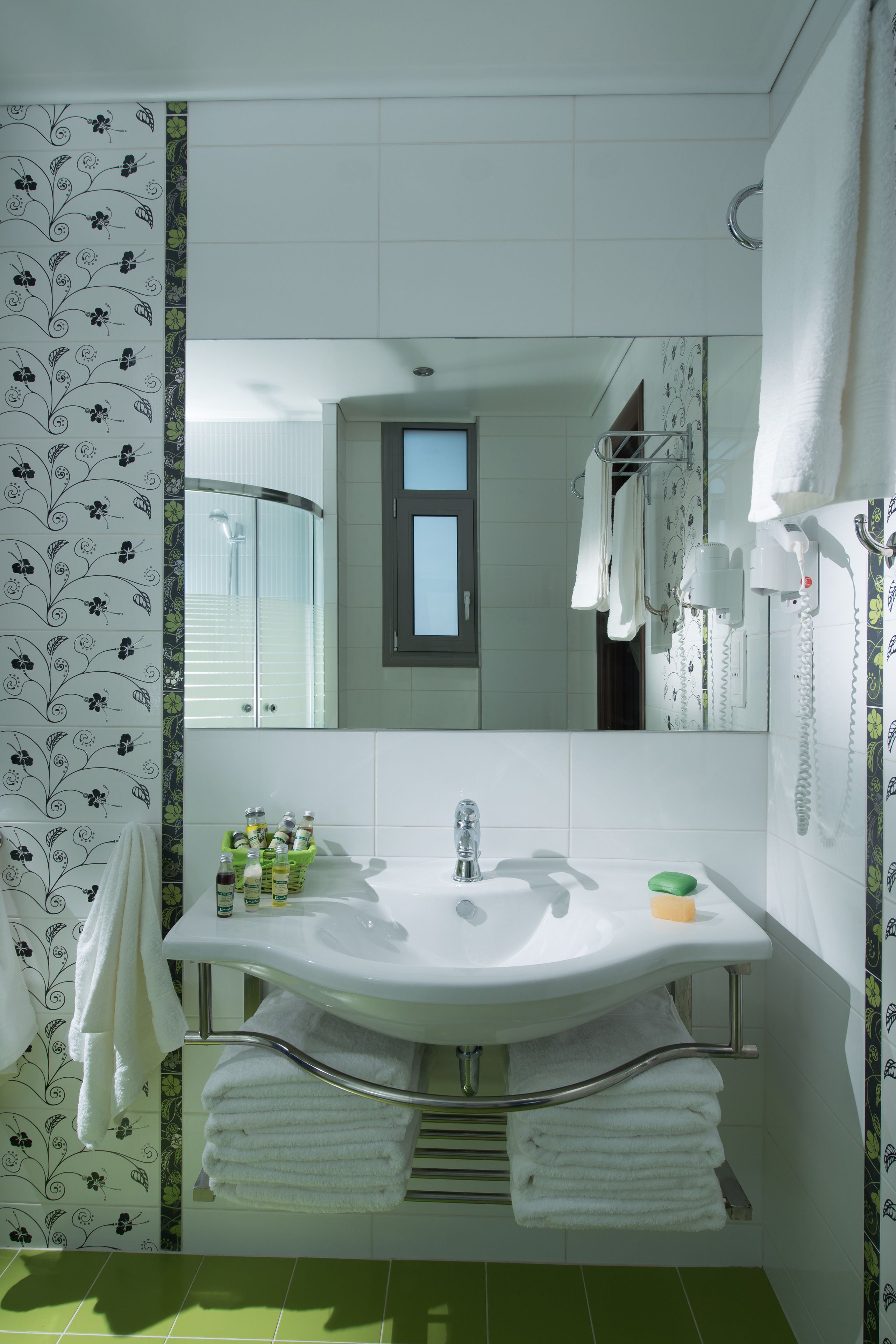 A bathroom with a white sink, mirror, and towel rack.