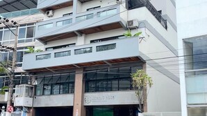 A multi-story hotel with a modern design, featuring balconies on each floor, large windows, and a visible entrance with a car parked outside. - Stratus Centro Hotel (Volta Redonda)