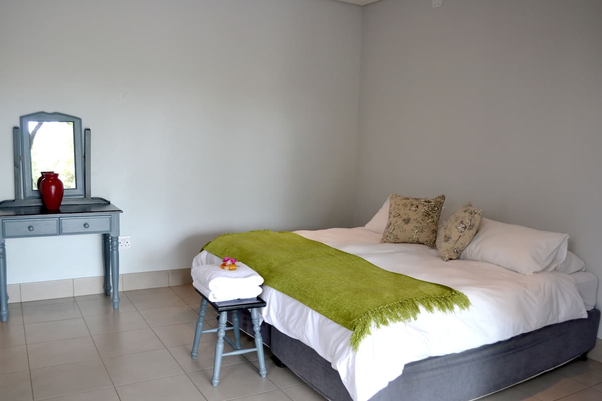Ein Schlafzimmer mit Bett, Schreibtisch und Stuhl.