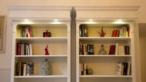 A bookshelf with books and decorative items. - Sui Tetti di Napoli (Naples)