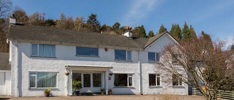 A two-story house with a front porch, a garage, and a well-maintained lawn.