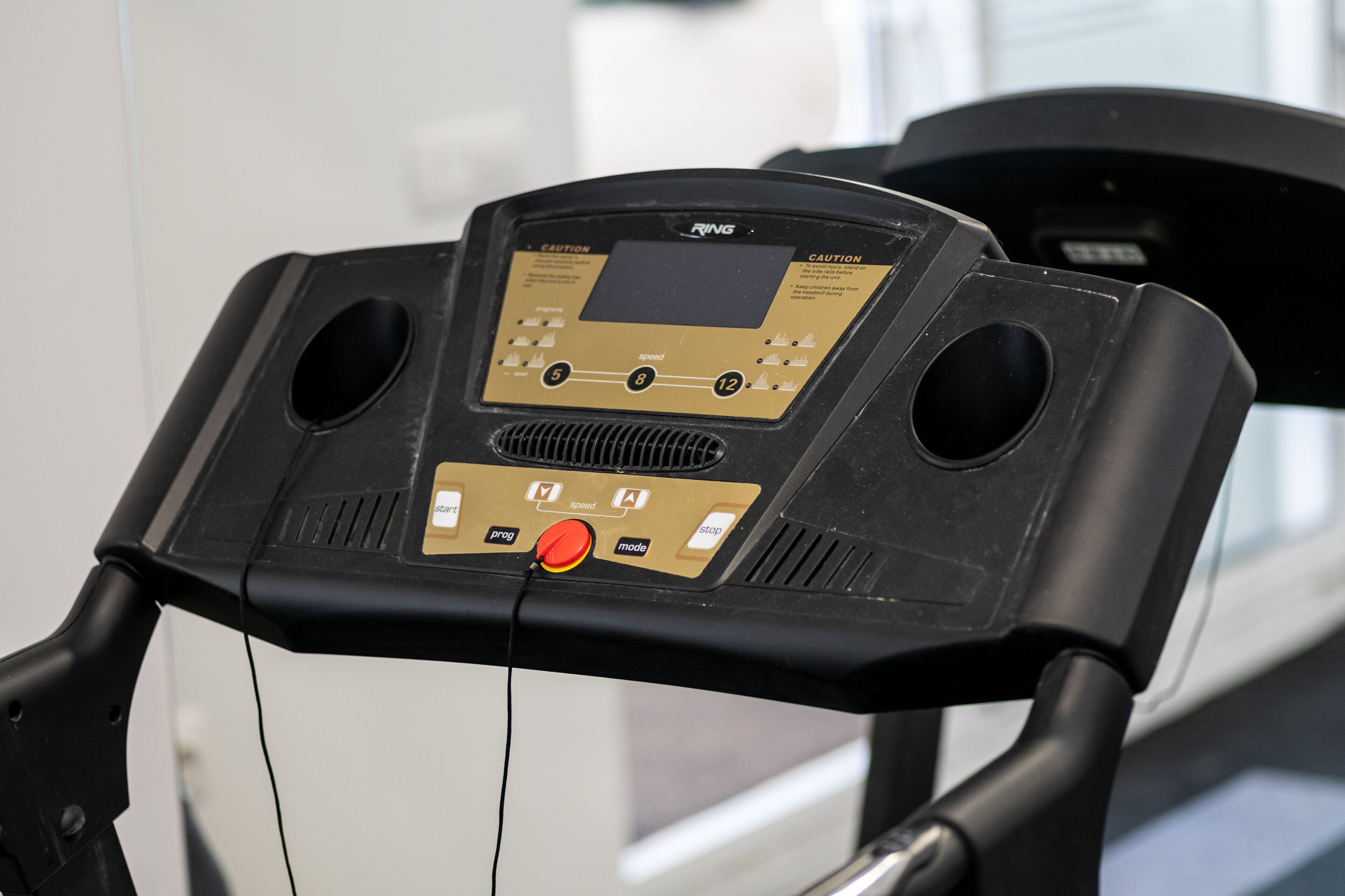 A treadmill control panel with speed settings and a red start button.
