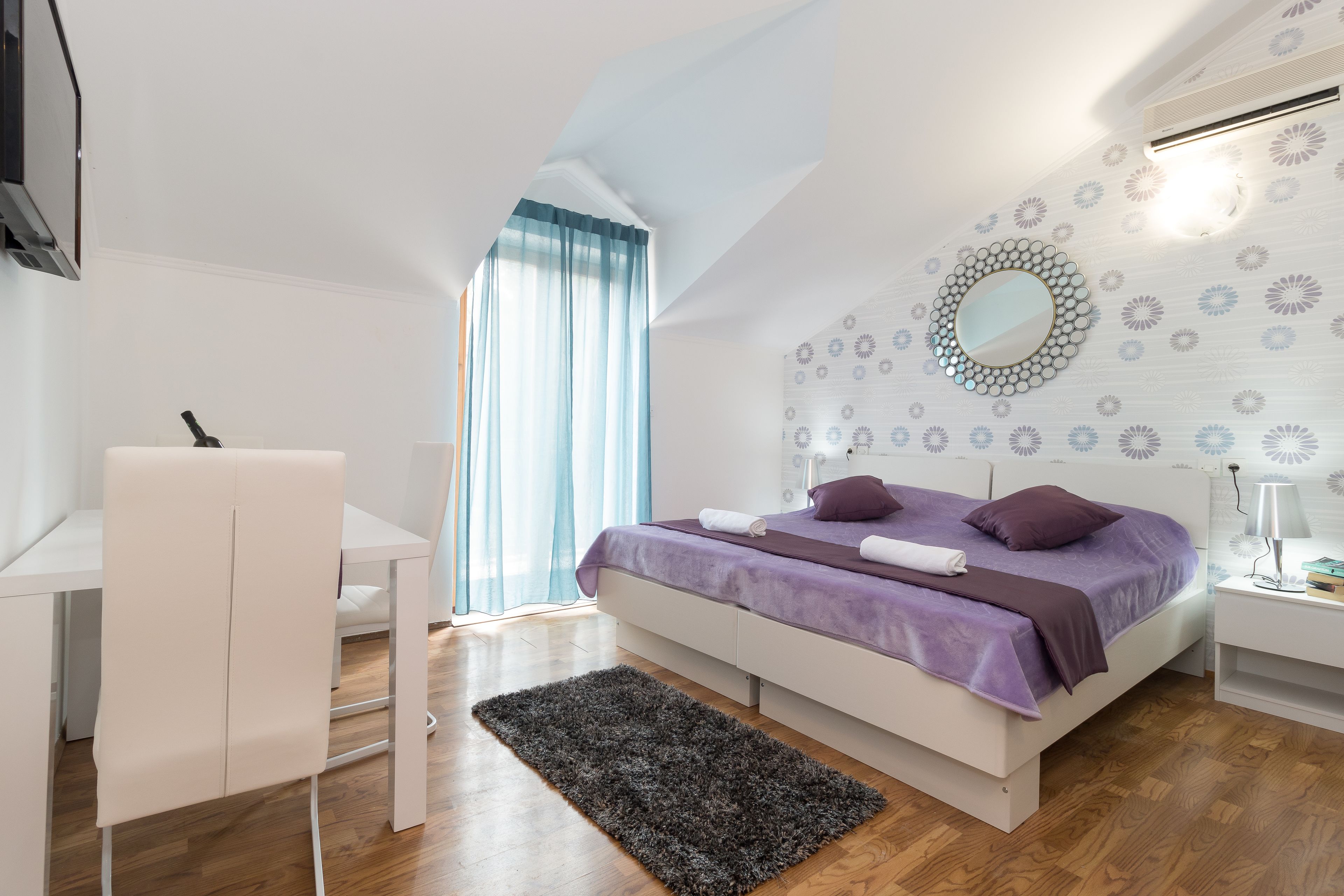 A modern bedroom with a bed, a desk, and a chair.