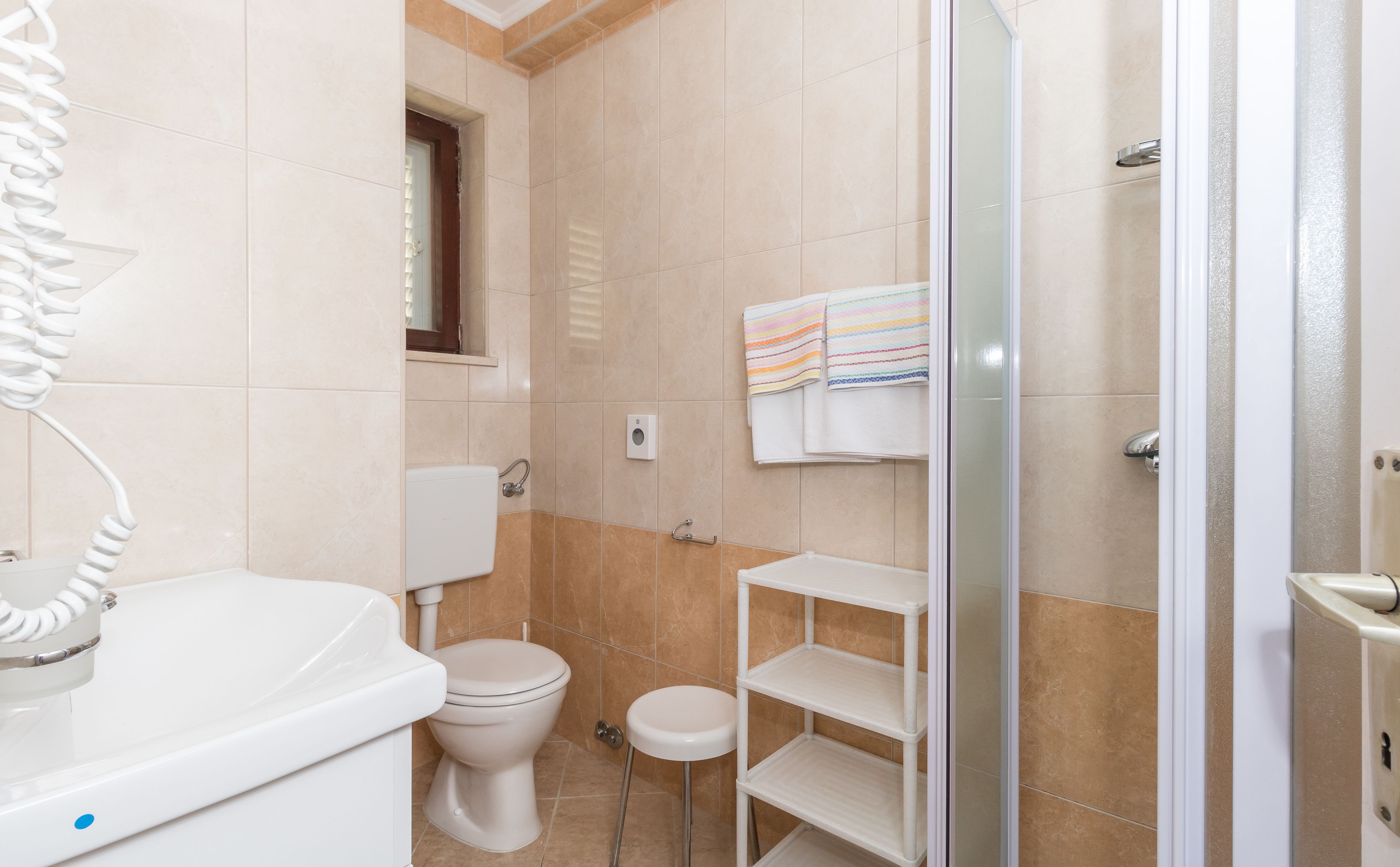 A bathroom with a toilet, sink, and shower area.