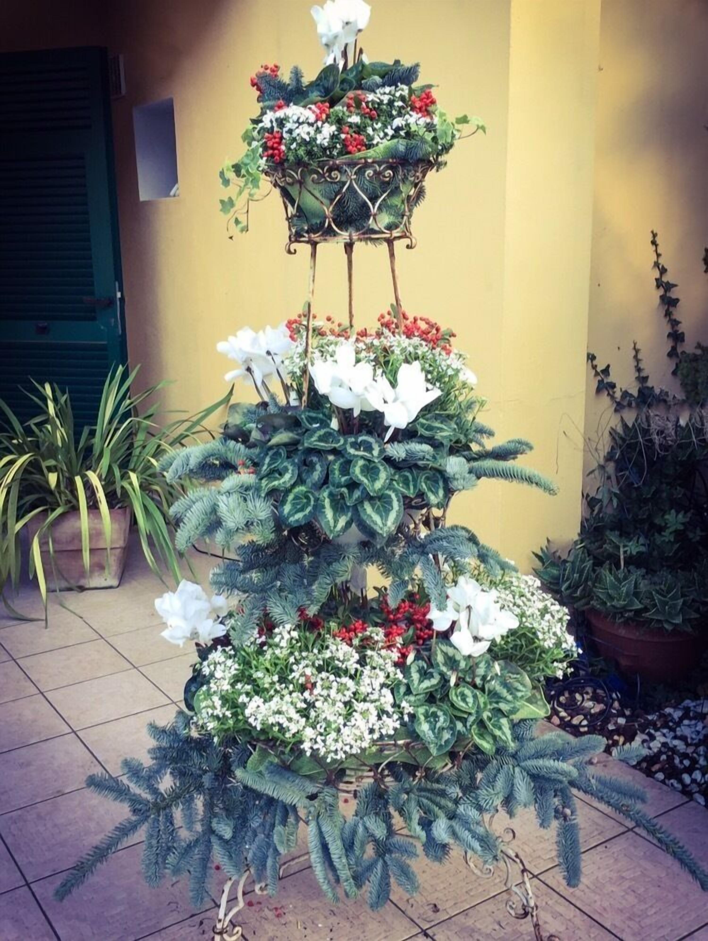 A tiered floral display with various plants and flowers.