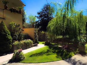 Ein gepflegter Garten mit vielfältigen Pflanzen und einem deutlichen Weg zu einem Gebäude.