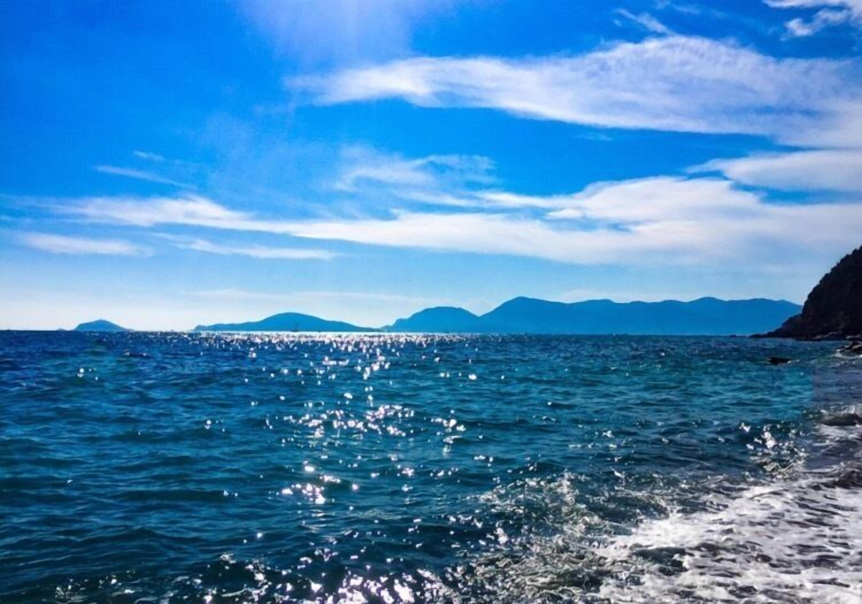 Une vue sur la côte, avec un ciel bleu dégagé et une mer calme.