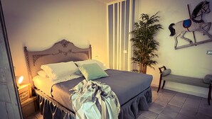 A bedroom with a bed, bedside table, lamp, and a wall-mounted horse sculpture. - Le Pinette Bed and Breakfast (Ameglia)