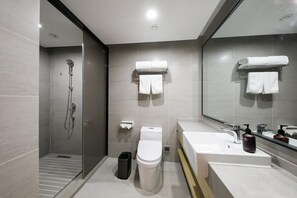 Enjoy a refreshing shower in the bathroom, featuring a walk-in shower, toilet, and sink with a mirror.