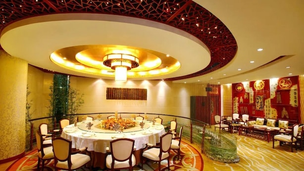 A formal dining room with a round table, chairs, and a decorative centerpiece. - Media Center Hotel - Beijing (BEIJING)