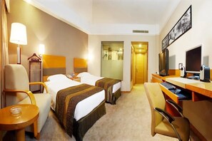 A hotel room with two beds, a desk with a computer, a chair, a lamp, and a television. - Media Center Hotel - Beijing (BEIJING)