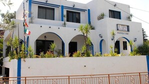 A white building with blue accents, featuring a sign that reads "Hotel Antija Sun." - Anthoula Sun (Rhodes)