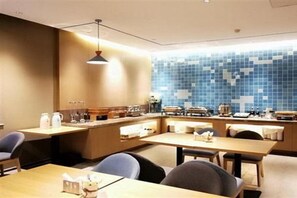A modern kitchen with a blue mosaic backsplash, wooden cabinets, and a central island with seating. - Home Inn Qianmen (BEIJING)