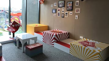 A modern hotel room with a large window, a view of a water park, and a wall decorated with framed photos.