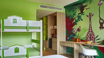 Een kinderbed met stapelbedden in groen en wit, een bureau met stoel, en een muurschildering van een giraffe en vlinders.