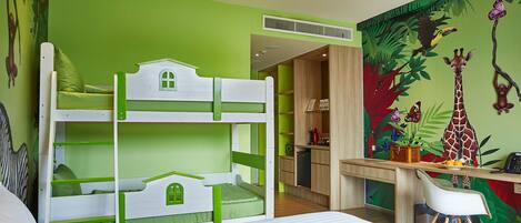 Una litera infantil con una combinación de colores verde y blanco, un escritorio con una silla, y un mural con una jirafa y mariposas en la pared.