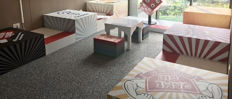 A modern office space with cubicles, a bulletin board, and a view of a cityscape through large windows.