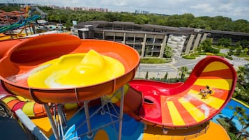 A water park with colorful slides and a building in the background.