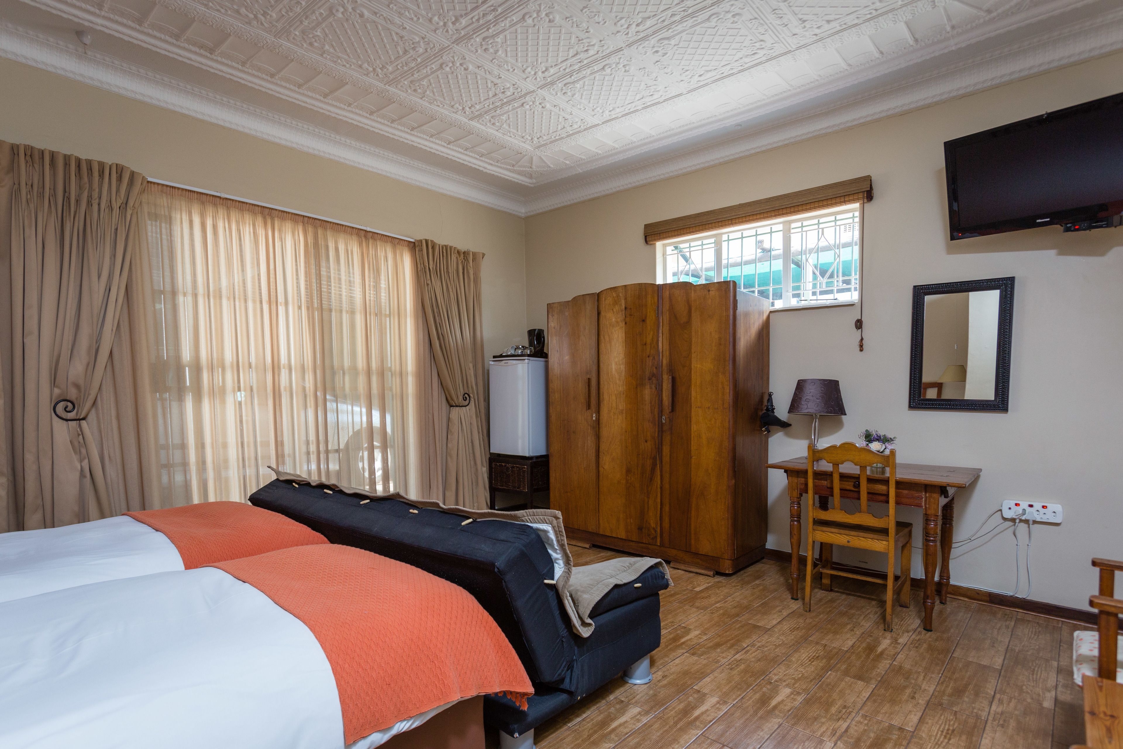 Une chambre d’hôtel équipée d’un lit, d’un bureau, d’une armoire et d’un téléviseur.
