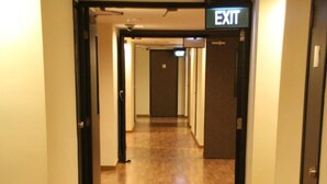 Ein Hotelgang mit Holzboden und Türen an beiden Seiten.