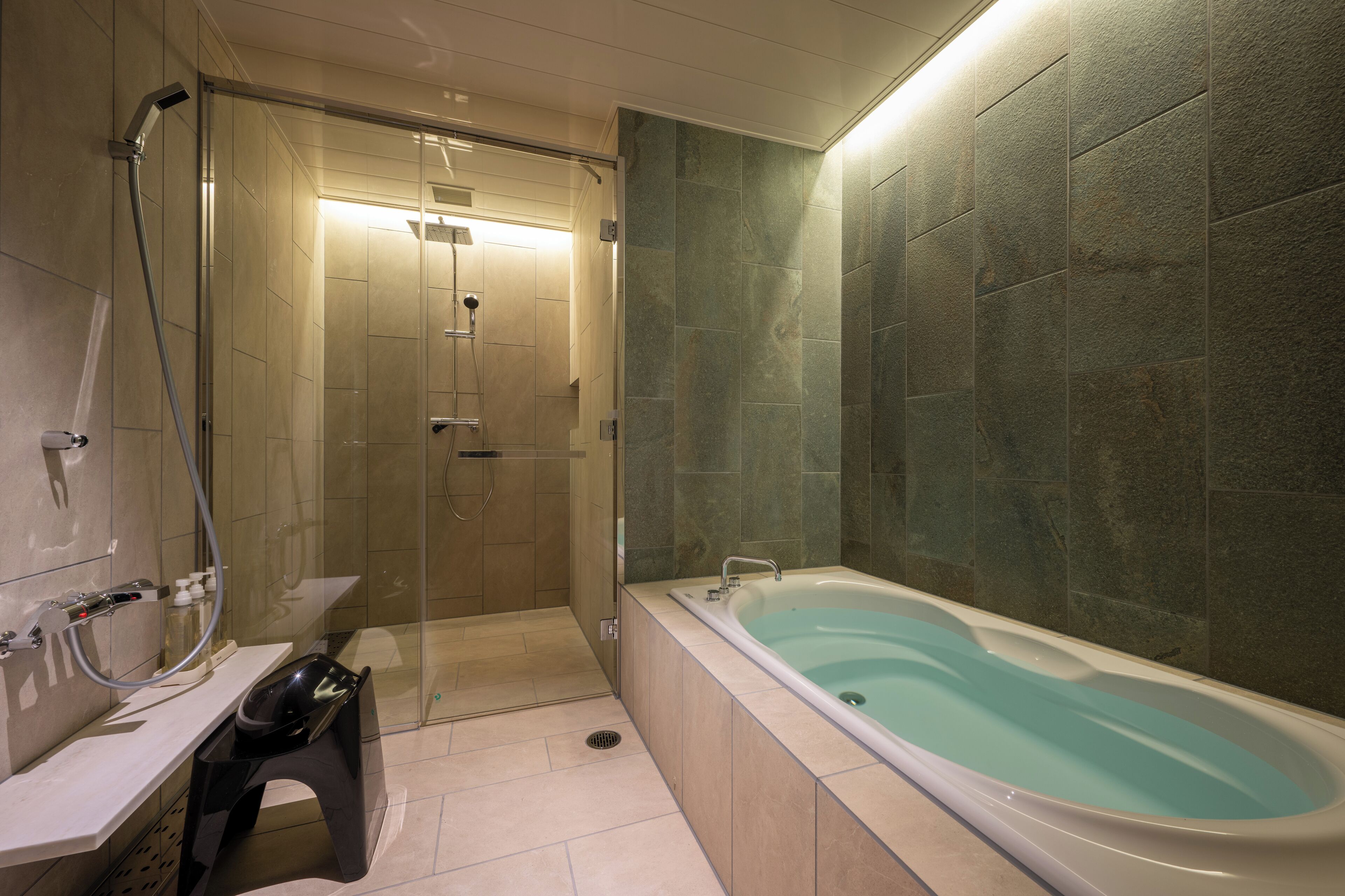 A modern bathroom with a glass-enclosed shower, a freestanding bathtub, and a vanity with a mirror.