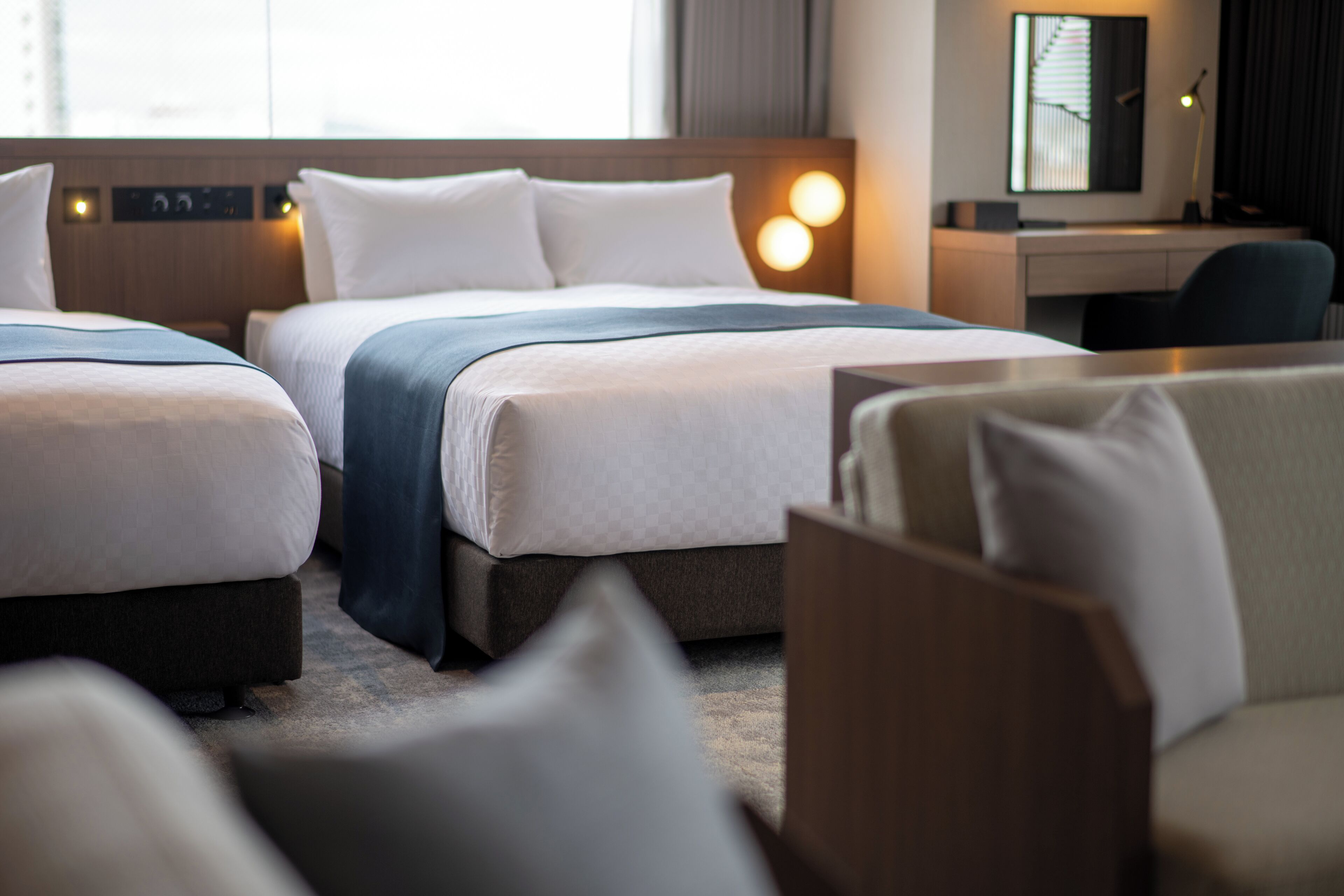 Une chambre d’hôtel avec deux lits, un bureau et une chaise.