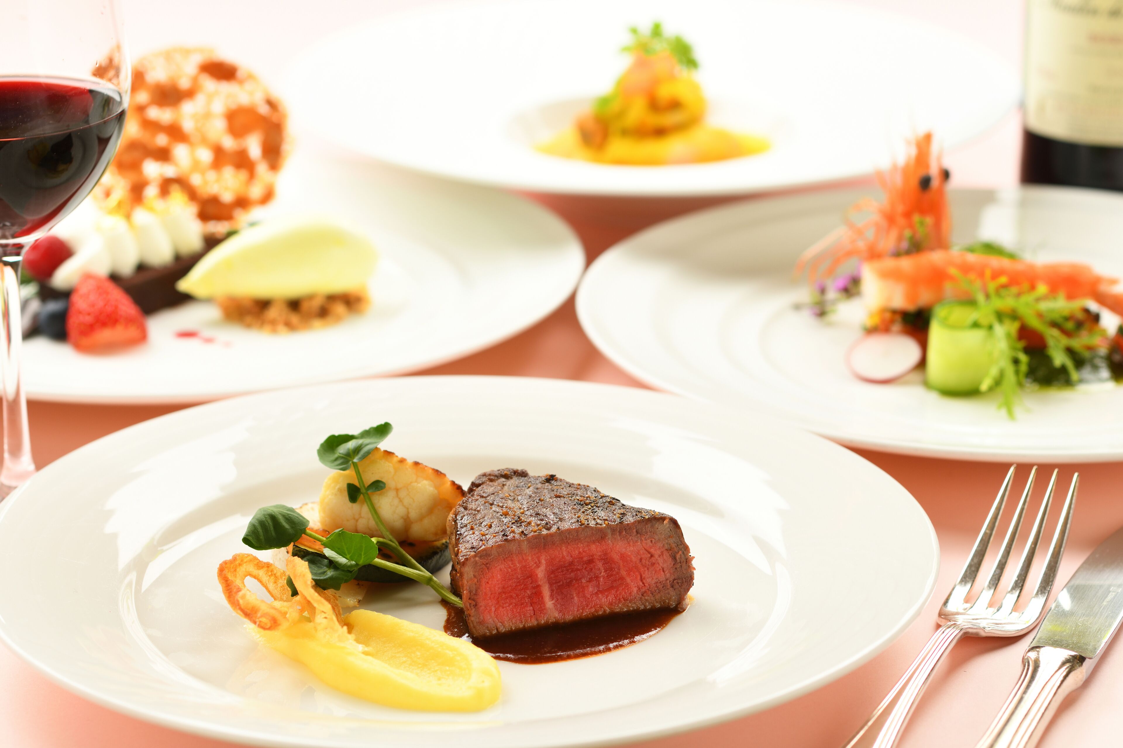 A table set with multiple plates of food, including steak and various appetizers.
